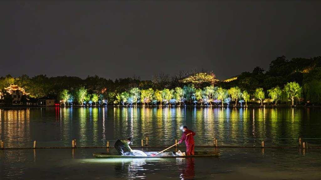工作人员在西湖清理荷塘